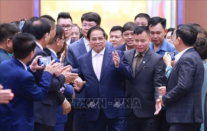 El primer ministro Pham Minh Chinh con empresas que asisten a un seminario sobre desarrollo del sector privado. (Foto: VNA)