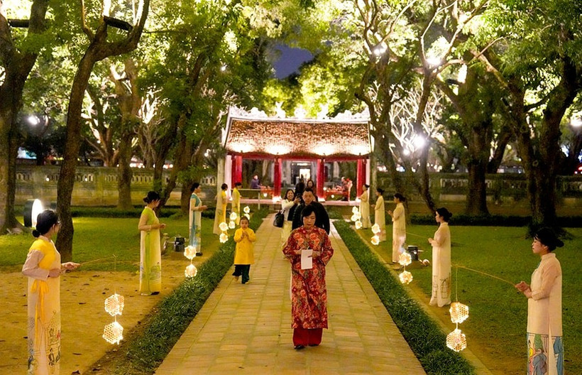 Turistas disfrutan del recorrido nocturno "Sonidos de Vietnam" en el Templo de la Literatura. (Foto: hanoimoi.vn)