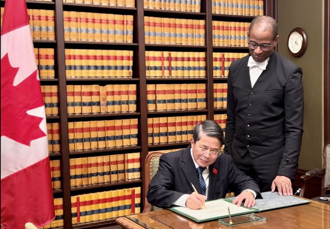 El vicepresidente de la Asamblea Nacional de Vietnam, Nguyen Duc Hai, escribe en el libro de recuerdos durante la visita de cortesía al titular de la Cámara de los Comunes de Canadá, Greg Fergus. (Fuente: VNA) hình_ảnh (11).jpg