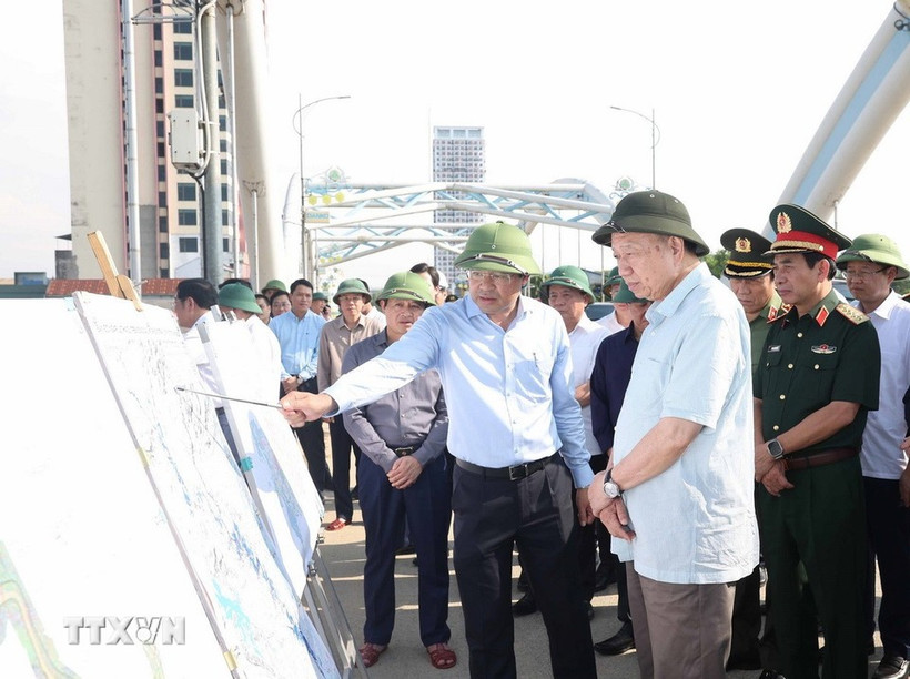 El secretario general del Partido Comunista de Vietnam, To Lam, escucha el informe del líder de la provincia de Thai Nguyen sobre las labores para superar las consecuencias de la tormenta y las inundaciones en el puente Ben Tuong. (Foto: VNA)