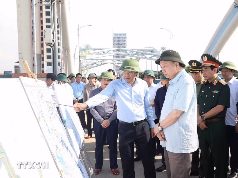 El secretario general del Partido Comunista de Vietnam, To Lam, escucha el informe del líder de la provincia de Thai Nguyen sobre las labores para superar las consecuencias de la tormenta y las inundaciones en el puente Ben Tuong. (Foto: VNA)