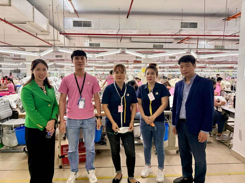 Le Ngoc Toan, primer secretario y jefe de la Junta Directiva de trabajadores y expertos en Malasia (primero a la derecha) y trabajadores vietnamitas en la empresa Ramatex Textiles. (Fuente: VNA)