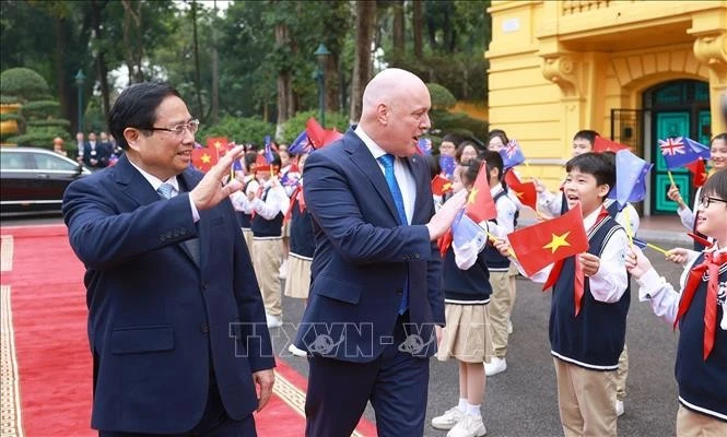 El primer ministro de Vietnam, Pham Minh Chinh, y su homólogo neozelandés, Christopher Luxon, con los estudiantes de Hanoi. (Fuente: VNA)