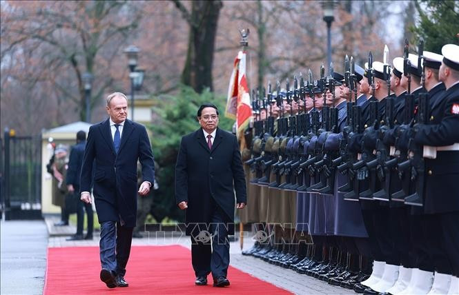 El primer ministro de Polonia, Donald Tusk, y su homólogo vietnamita, Pham Minh Chinh, pasan revista a la guardia de honor. (Fuente: VNA)