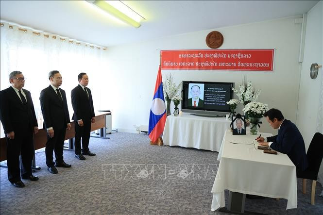 El embajador Mai Phan Dung, jefe de la misión permanente de Vietnam en Ginebra, firma el libro de condolencias en la sede de la misión de Laos. (Fuente: VNA)