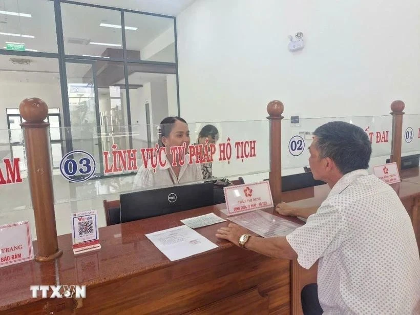 Las personas hacen trámites administrativos en el día del inicio de la prueba del gobierno de dos niveles en el distrito de Pleiku, Gia Lai. (Fuente: VNA)