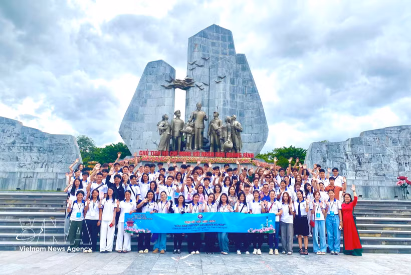 110 jóvenes y estudiantes vietnamitas residentes en el extranjero, junto con delegados, posan para una foto conmemorativa en el Monumento al Presidente Ho Chi Minh y al pueblo de Quang Binh (2025); barrio de Dong Hoi, provincia de Quang Tri). Foto: VNA