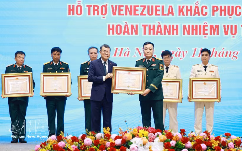 El primer ministro Le Minh Hung (izquierda) otorga las Órdenes de Defensa de la Patria de Primera y Segunda Clase a los colectivos que sobresalieron en las labores de búsqueda y rescate, asistencia humanitaria y respuesta al desastre en Venezuela. (Foto: VNA)