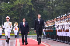 El primer ministro Pham Minh Chinh y el presidente del Gobierno de España, Pedro Sánchez, pasan revista a la Guardia de Honor del Ejército Popular de Vietnam. (Foto: VNA)