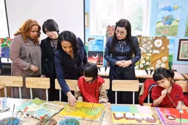 Le Thi Bich Tran, esposa del primer ministro Pham Minh Chinh, y Zinash Tayachew, esposa del primer ministro etíope Abiy Ahmed Ali, visitan la sala de arte, donde se exhiben pinturas realizadas por estudiantes con discapacidad visual en la escuela secundaria Nguyen Dinh Chieu. (Foto: VNA)