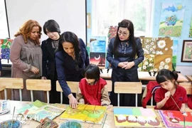 Le Thi Bich Tran, esposa del primer ministro Pham Minh Chinh, y Zinash Tayachew, esposa del primer ministro etíope Abiy Ahmed Ali, visitan la sala de arte, donde se exhiben pinturas realizadas por estudiantes con discapacidad visual en la escuela secundaria Nguyen Dinh Chieu. (Foto: VNA)