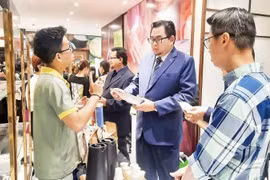 Inversionistas de inversión extranjera directa examinan productos alimenticios expuestos en el Centro de Promoción del Comercio y la Inversión de Ciudad Ho Chi Minh. (Foto: nhandan.vn)
