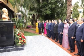 El presidente Luong Cuong, su esposa y la delegación vietnamita de alto rango ofrecen respetuosamente flores frescas ante la estatua del Presidente Ho Chi Minh en la Embajada de Vietnam. (Foto: VNA)