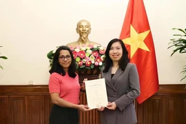 La viceministra de Relaciones Exteriores, Le Thi Thu Hang (der.), entrega la licencia para la apertura de la oficina permanente a Anantha Lakshmi, corresponsal residente del Financial Times y jefa de su oficina en Hanói, durante la ceremonia. (Foto: VNA)