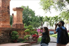Dos turistas rusos toman fotos con entusiasmo en la reliquia de la Torre Ponagar (Khanh Hoa). (Foto: VNA)