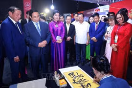 El primer ministro Pham Minh Chinh visita un stand vietnamita en el evento (Foto: VNA)
