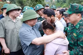 El primer ministro Pham Minh Chinh consuela a una familia cuyo miembro falleció en las recientes inundaciones en la comuna de Xa Dung. (Foto: VNA)