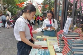 Los estudiantes leen libros en la calle de los libros de Hanoi. (Foto: VNA)