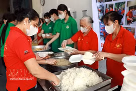 Los miembros de la Asociación de Comidas Solidarias y estudiantes de la escuela secundaria Nguyen Khuyen (barrio Nam Dinh) preparan raciones de comida gratuitas para entregar a los pacientes. (Foto: VNA)