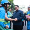 El primer ministro Pham Minh Chinh y trabajadores ambientales. (Fuente: VNA)