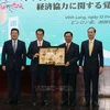 El secretario del Comité del Partido de Vinh Long, Tran Van Lau, entrega un obsequio conmemorativo a Tokihiro Nakamura, gobernador de la prefectura de Ehime, Japón. (Foto: VNA)