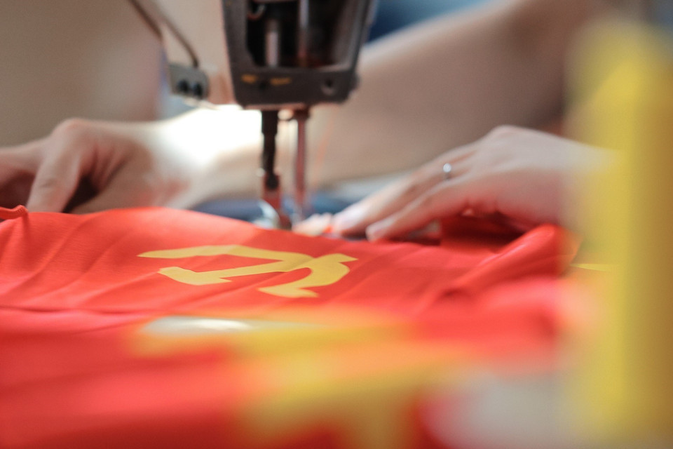 Las máquinas de coser banderas nacionales y del Partido funcionan a plena capacidad. Foto: VNA