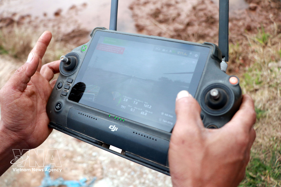 Un miembro de la Cooperativa Juvenil Nam Dai Duong maneja un dron para la siembra de arroz. Foto: Nguyen Lanh– VNA