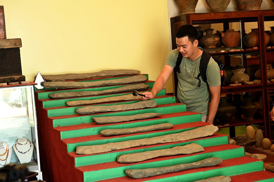 Visitantes experimentan el conjunto de litófonos Ngu am de 20 piezas, con más de 3.000 años de antigüedad, en el Museo. Foto: Hong Hieu – VNA