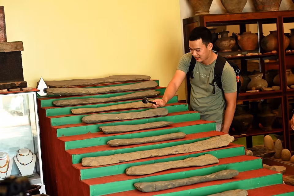Visitantes experimentan el conjunto de litófonos Ngu am de 20 piezas, con más de 3.000 años de antigüedad, en el Museo. Foto: Hong Hieu – VNA