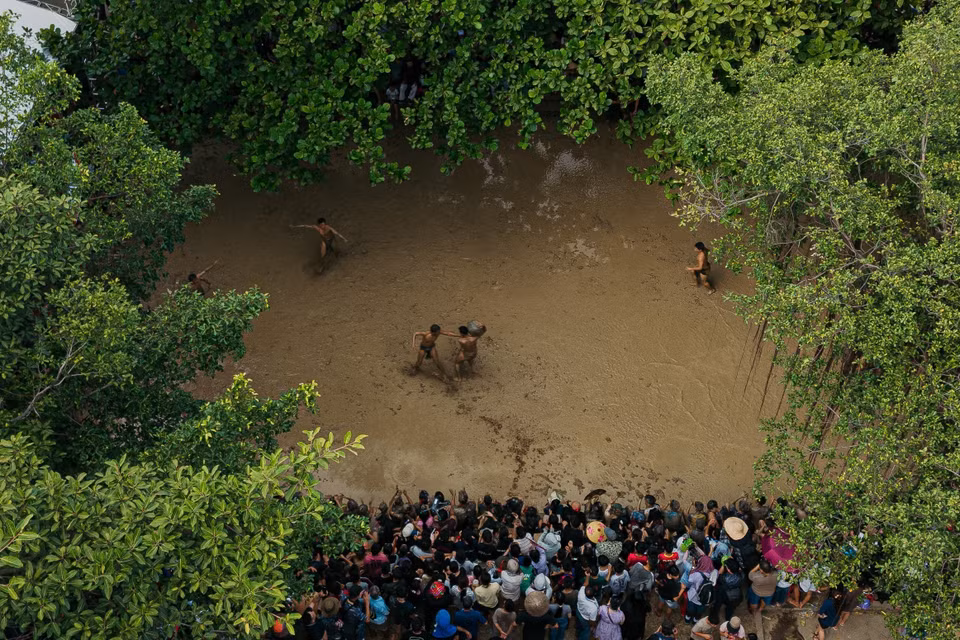 Vista panorámica del campo de barro del festival de lucha por la bola de agua desde arriba. En medio del verdor de los árboles centenarios y de la multitud que rodea el campo, el festival aparece como una actividad comunitaria singular, estrechamente ligada a la vida cultural de los habitantes de la región de Kinh Bac. Foto: VNA