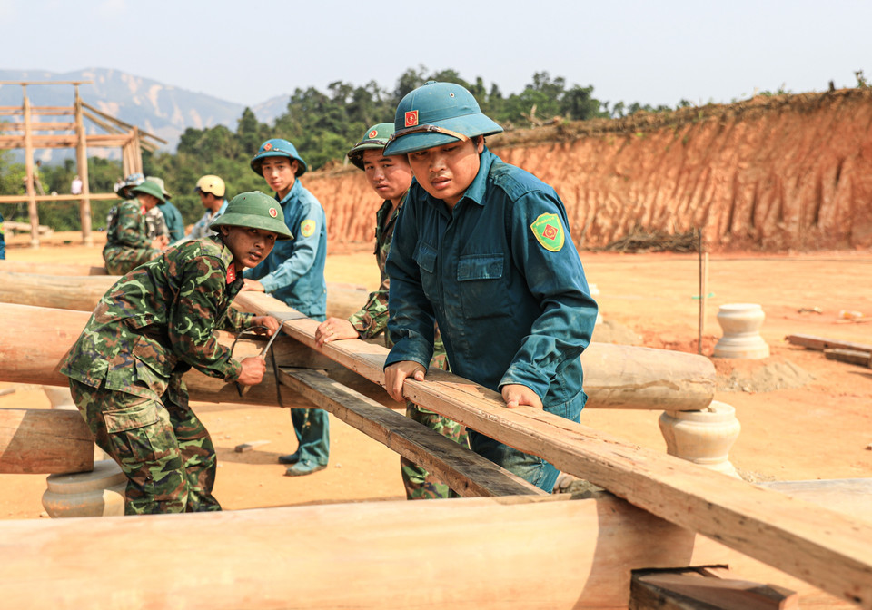 Las milicias de autodefensa de la comuna de Muong Bon ayudan a los residentes a levantar casas sobre pilotes en la aldea de Muong Pon 2. Foto: VNA