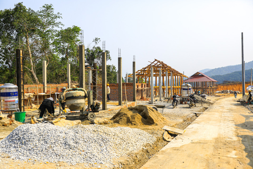 Oficiales y soldados del Regimiento 741 ayudan a los residentes a excavar el terreno para nivelar el suelo de las viviendas en la aldea de Muong Pon 2. Foto: VNA