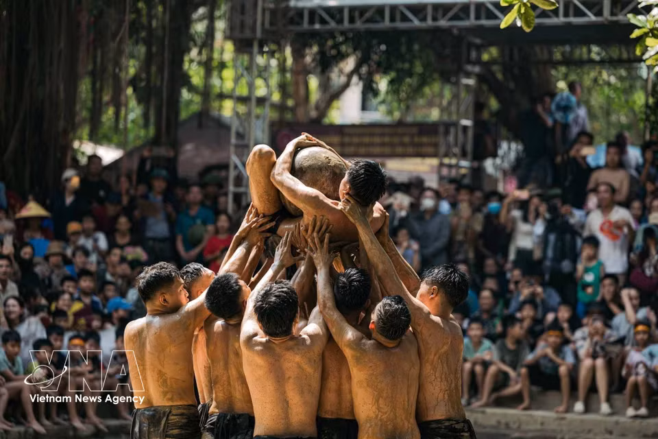 Antes de iniciar la disputa, los jugadores realizan el ritual de levantar la bola, alzando al portador de la bola de madera entre los vítores de los aldeanos. Foto: VNA