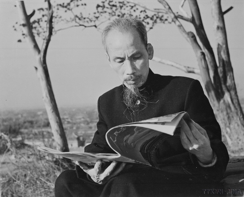 El Presidente Ho Chi Minh no solo fue periodista, sino también un lector activo de la prensa nacional e internacional. Desarrolló el hábito de leer periódicos de manera constante y rigurosa. En la foto: El Presidente Ho Chi Minh leyendo un periódico frente a su casa de descanso durante su visita a China en 1953. Foto: VNA