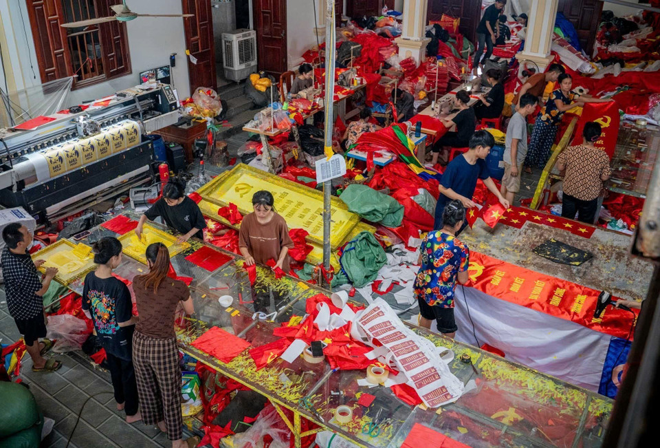 Cuanto más se acerca el Día Nacional, más animada y ajetreada se torna la producción en las familias dedicadas a la confección de banderas nacionales en la aldea. Foto: VNA