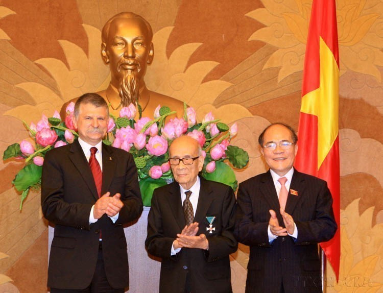 El presidente del Parlamento de Vietnam, Nguyen Sinh Hung, y su homólogo de Hungría, László Kövér, felicitan al Profesor Vu Khieu por recibir la Orden de la Cruz de Caballero de Hungría (Hanoi, 9 de noviembre de 2015). Foto: VNA