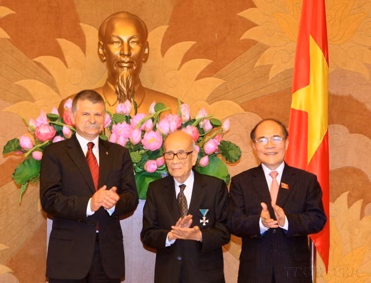 El presidente del Parlamento de Vietnam, Nguyen Sinh Hung, y su homólogo de Hungría, László Kövér, felicitan al Profesor Vu Khieu por recibir la Orden de la Cruz de Caballero de Hungría (Hanoi, 9 de noviembre de 2015). Foto: VNA