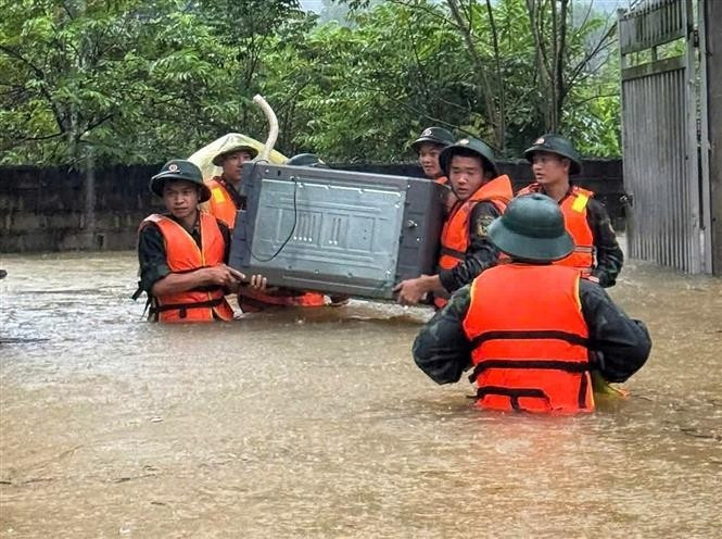 Oficiales y soldados de la Brigada 409 y del Comando Militar de la provincia de Bac Ninh ayudan a los habitantes de la comuna de Xuan Luong a trasladar personas y bienes. Foto: VNA