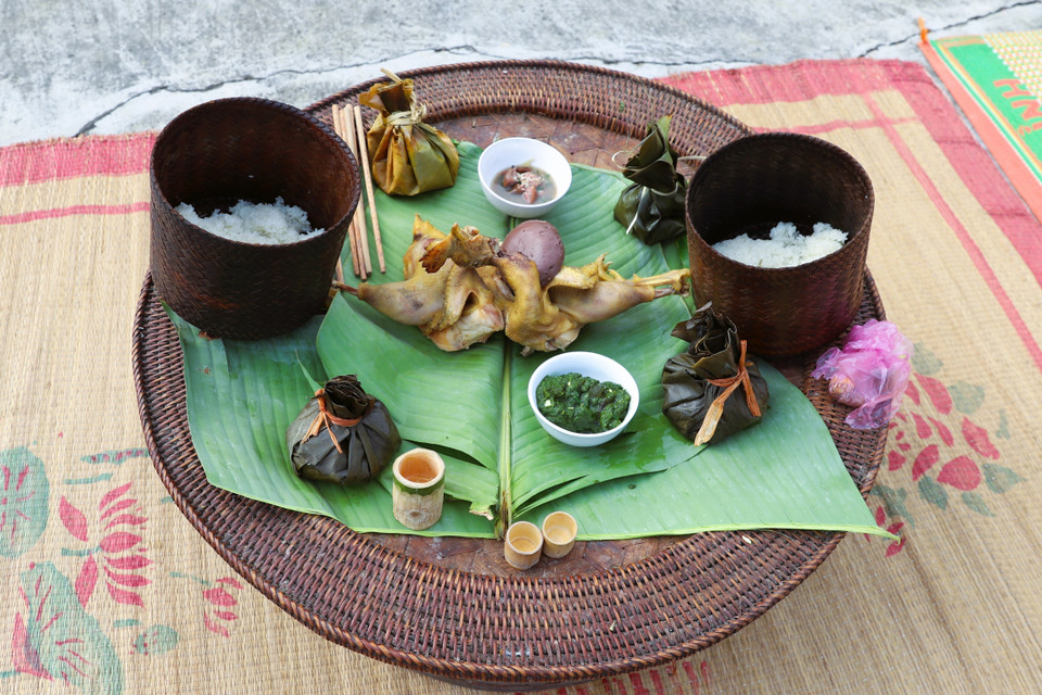 Las ofrendas sobre la bandeja ceremonial incluyen pollo hervido, arroz glutinoso, licor servido en una copa de bambú, arroz con pescado o carne y especias envueltos en hoja de plátano, y ensalada de musgo de arroyo servida en cuencos de porcelana. Foto: VNA