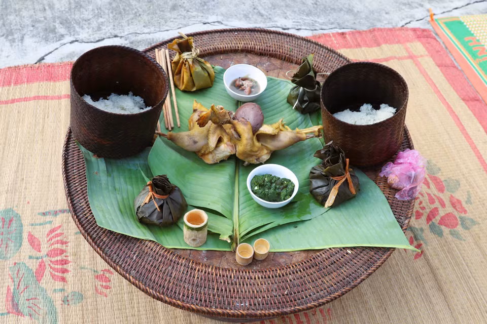Las ofrendas sobre la bandeja ceremonial incluyen pollo hervido, arroz glutinoso, licor servido en una copa de bambú, arroz con pescado o carne y especias envueltos en hoja de plátano, y ensalada de musgo de arroyo servida en cuencos de porcelana. Foto: VNA