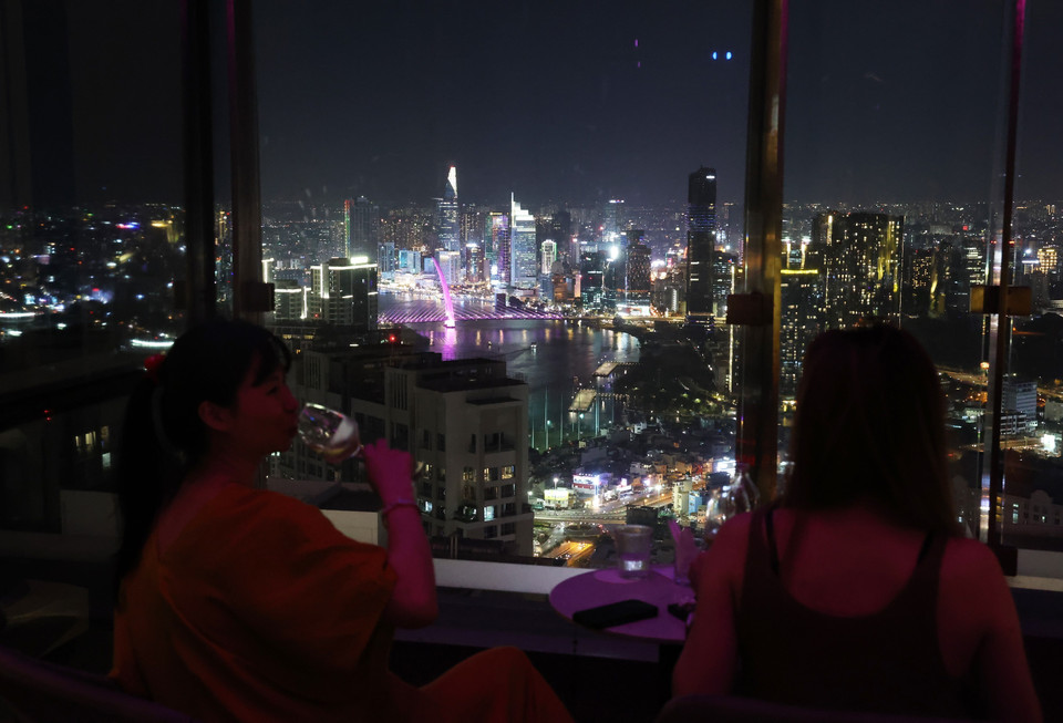 Clientes disfrutan del espacio The Club Lounge en Vinpearl Landmark 81, con vistas panorámicas del centro de Ciudad Ho Chi Minh de noche. Foto: Hong Dat – VNA