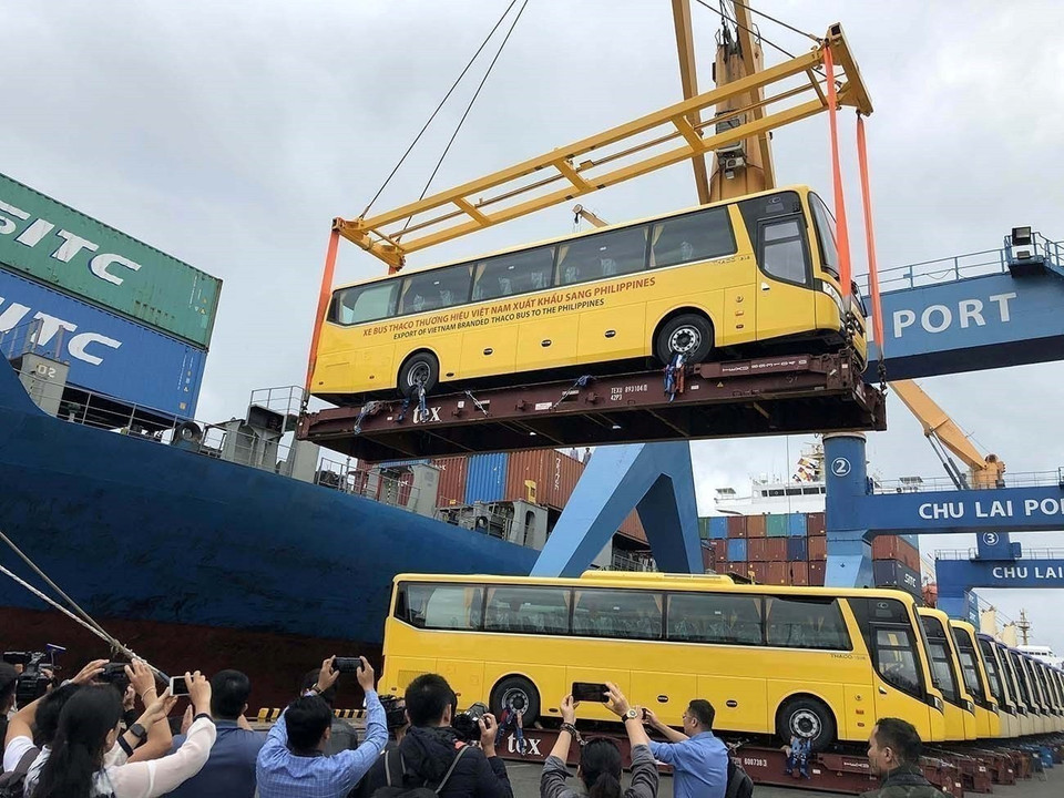 La economía de mercado con orientación socialista se fue formando y desarrollando gradualmente. En la imagen: Ceremonia de entrega de 15 autobuses de la marca vietnamita THACO exportados a Filipinas, en el puerto de Chu Lai (Zona Económica Abierta de Chu Lai, provincia de Quang Nam). Foto: Tran Tinh – VNA