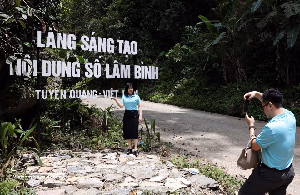 Turistas toman fotografías y realizan actividades de “check-in” en la Aldea de Creación de Contenidos Digitales de la comuna de Lam Binh. Foto: VNA