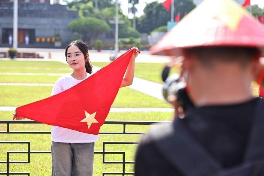 La bandera roja con estrella amarilla es un accesorio imprescindible en las fotos para celebrar la gran festividad. Foto: VNA