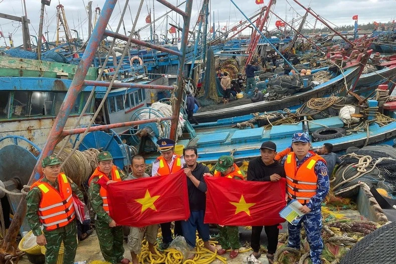 Guardias fronterizos de Hai Phong entregan banderas nacionales a pescadores en el puerto de Bach Long Vy. (Foto: VNA)