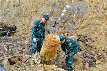 Las autoridades trasladan la bomba al lugar de la detonación. (Foto: VNA)