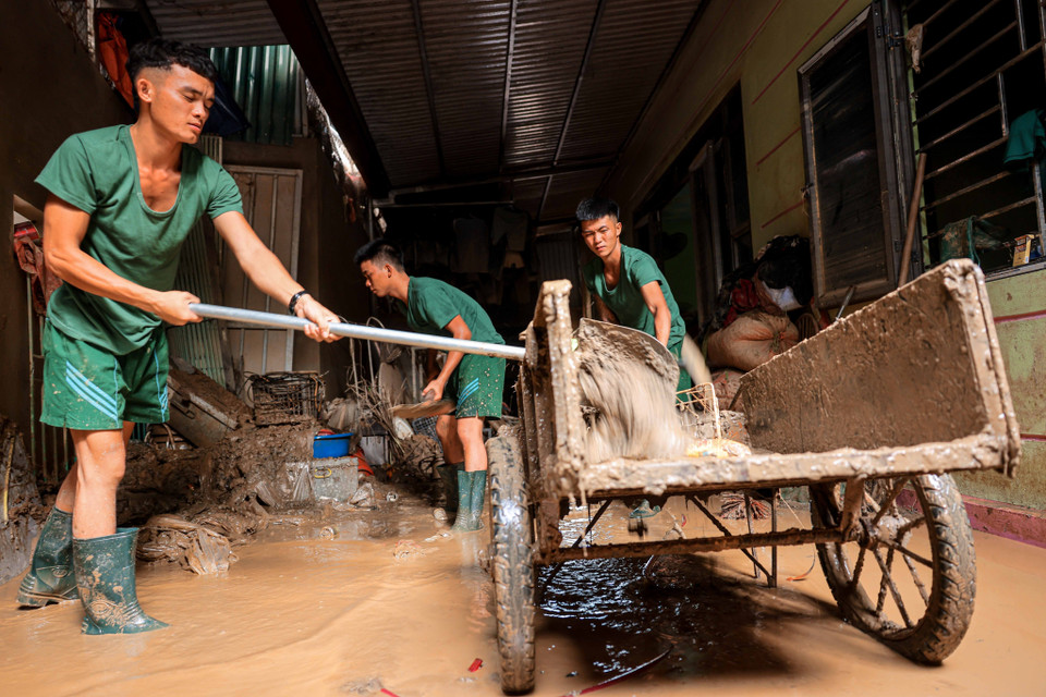 Los soldados de la División 316 ayudan a la gente de la comuna de Phuc Khanh, distrito de Bao Yen, a limpiar sus casas después de la inundación. (Foto: VNA)