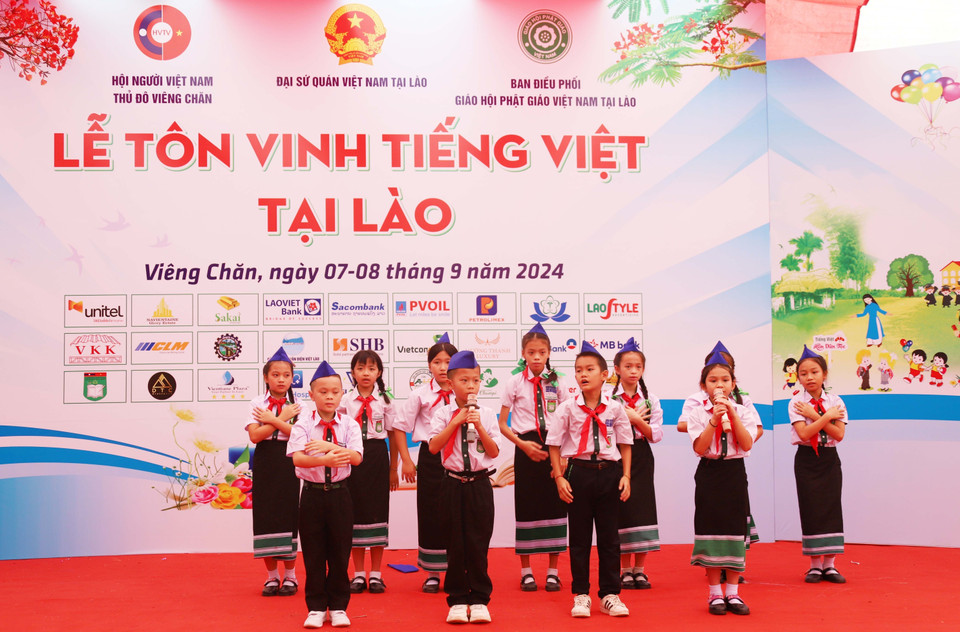 Estudiantes de Vietnam y Laos presentan una canción sobre el Tío Ho en la ceremonia de honor del idioma vietnamita en Laos en 2024. (Fuente: VNA)