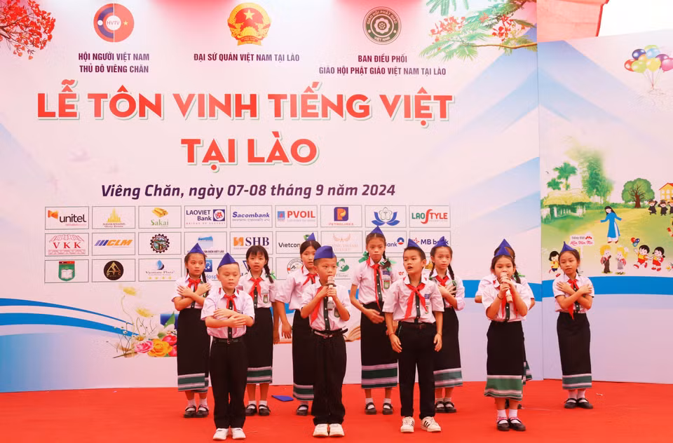 Estudiantes de Vietnam y Laos presentan una canción sobre el Tío Ho en la ceremonia de honor del idioma vietnamita en Laos en 2024. (Fuente: VNA)