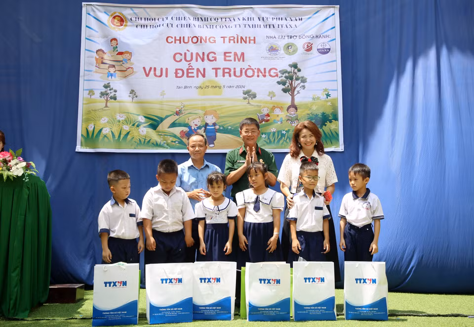 Tran Trang Duong, presidente de la Asociación de Veteranos de la VNA (centro) y Huynh Thi Mong Tuyen, directora de la empresa Yamamoto-Huynh, entregan obsequios a representantes de la escuela y los estudiantes. Foto: VNA